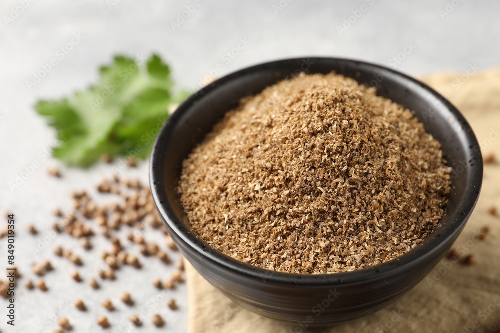 Coriander powder in bowl and seeds on table, closeup Coriander powder in bowl and seeds on table, closeup