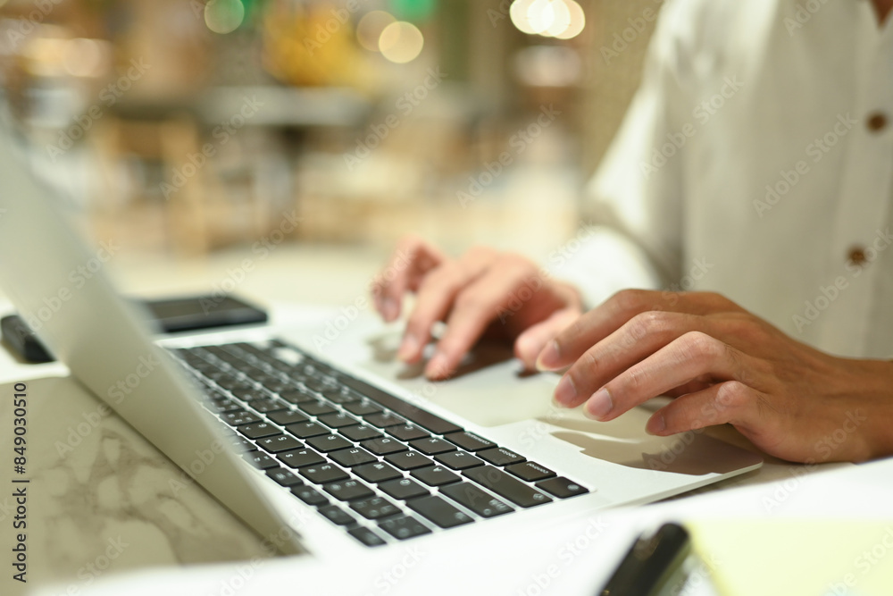 Close up of unrecognizable businessman typing at laptop keyboard remote work, browsing internet in office