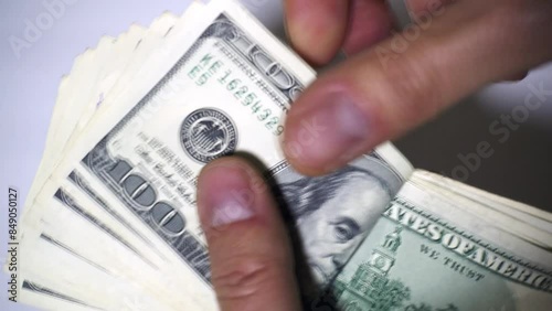 A rich man counts his monthly salary of $ 2,000 us dollars on a white background. Concept of earning, salary, salary, pay the mortgage, monthly expenses, count money, count dollars, earn money