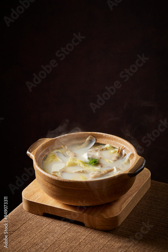 double boiled fresh Seafood clam shell in Chinese wine herbal ginger onion scallion dumpling hot soup in clay pot on wood table asian luxury hotel cafe restaurant banquet cuisine halal food menu