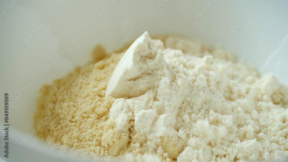 Mixing various dry ingredients for dough made in white bowls. Almond and coconut flour to cook tasty gluten-free cookies. Culinary routine. Healthy eating. Mixing various dry ingredients for dough made in white bowls. Almond and coconut flour to cook tasty gluten-free cookies. Culinary routine. Healthy eating.