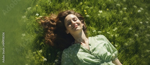 Fototapeta Naklejka Na Ścianę i Meble -  Happy young woman lying on green grass Warm spring Summer. Creative banner. Copyspace image