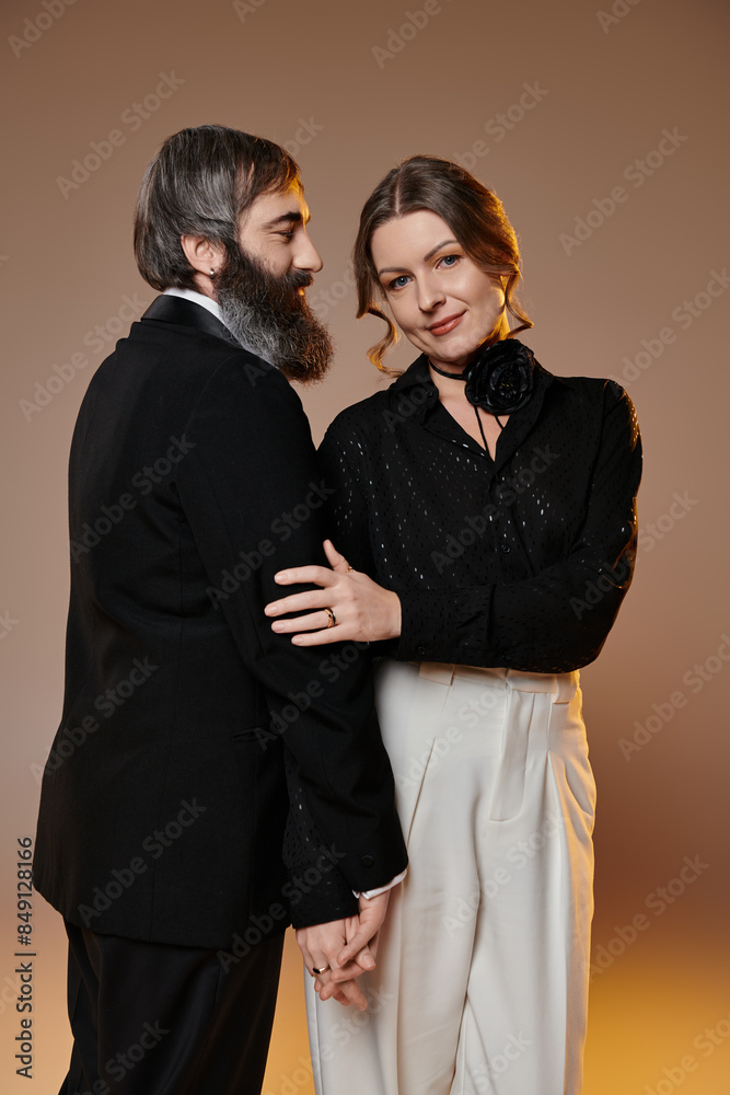 A man and woman in formal attire embrace, radiating love and sophistication. A man and woman in formal attire embrace, radiating love and sophistication.