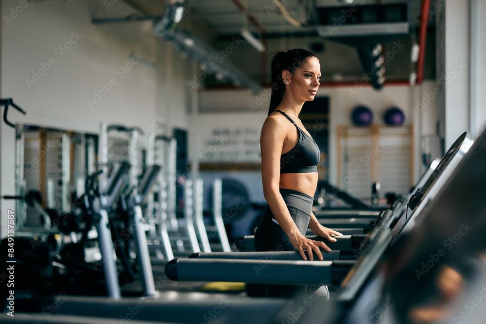 Fit girl starting a morning jog on a treadmill, dressed in a black sports outfit. Fit girl starting a morning jog on a treadmill, dressed in a black sports outfit.