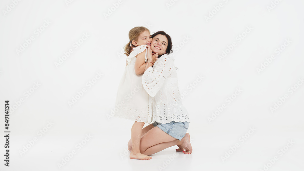 Family relationships between mother and daughter. Sensual mother with her little daughter on a light studio background. Tender moment, family support. Family relationships between mother and daughter. Sensual mother with her little daughter on a light studio background. Tender moment, family support.