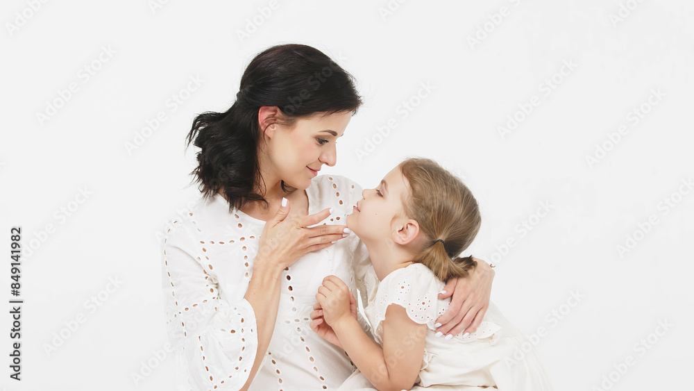 Mom's gentle touch. Close-up of a touching and tender mother and daughter on a light background. Family concept. Mom's gentle touch. Close-up of a touching and tender mother and daughter on a light background. Family concept.