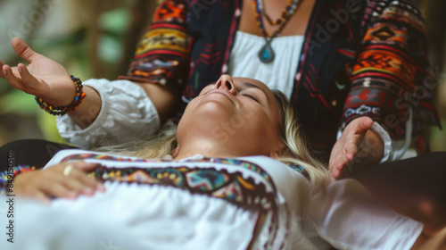 Woman receiving energy healing treatment in a serene outdoor setting.