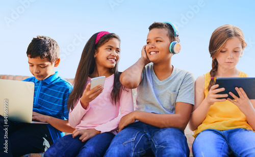School kids, happy with phone and tablet, laptop and headphones with diversity, relax and streaming in summer. Girl, boy and friends with tech, group and games with subscription on app outdoor