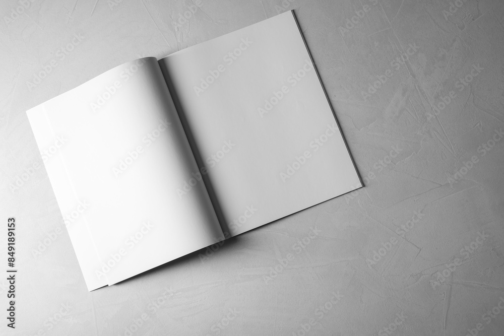 Open notebook with blank paper sheets on grey textured background, top view. Mockup for design Open notebook with blank paper sheets on grey textured background, top view. Mockup for design