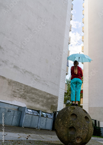 Fotografie Woman with umbrella between high-rise buildings