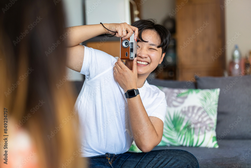 Young man photographing his girlfriend at home
Young man photographing his girlfriend at home