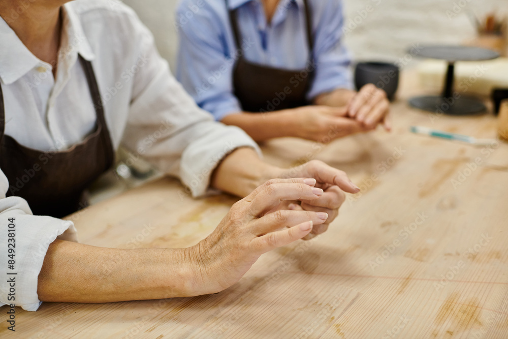 A close-up of a lesbian couples hands while crafting in a cozy pottery studio. A close-up of a lesbian couples hands while crafting in a cozy pottery studio.