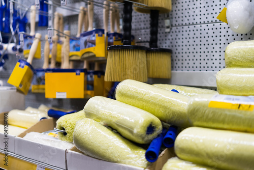 A store display of paint brushes and rollers. The display is organized by color and size.