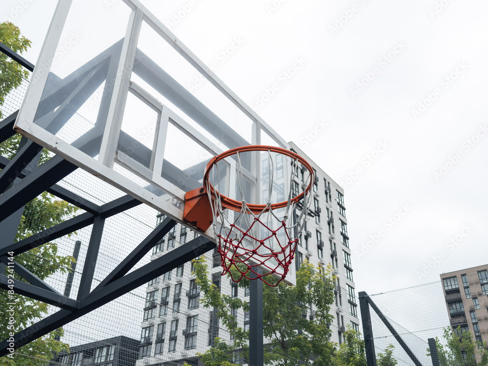 The basketball hoop on the court is under sunny weather The basketball hoop on the court is under sunny weather