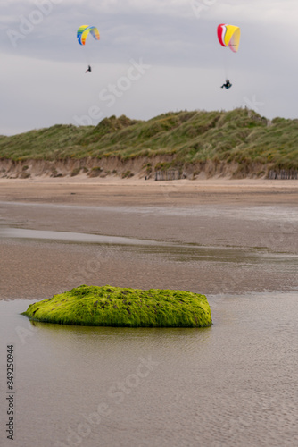 Paragliders flying above Donabate beach in Ireland, close to Dublin City.. Selective focus.