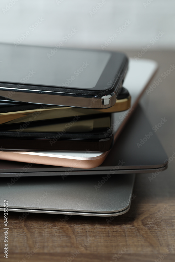 Stack of electronic devices on wooden table, closeup Stack of electronic devices on wooden table, closeup