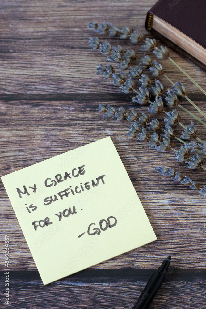 Naklejka premium My grace is sufficient for you, God, handwritten biblical quote with holy bible and lavender on wood. Top view. Spiritual strength, Jesus Christ's power and mercy, Christian concept.