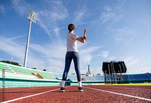 육상경기장에서 달리기를 시작하기 전 스트레칭으로 준비운동 하는 여자 photo