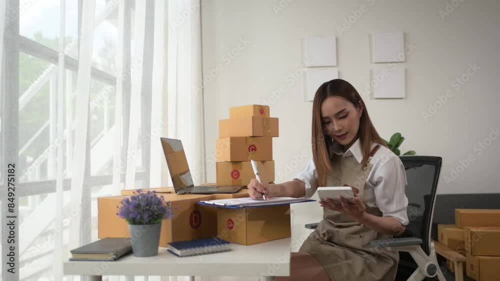 A woman is sitting at a desk with a laptop and a stack of boxes in front of her A woman is sitting at a desk with a laptop and a stack of boxes in front of her