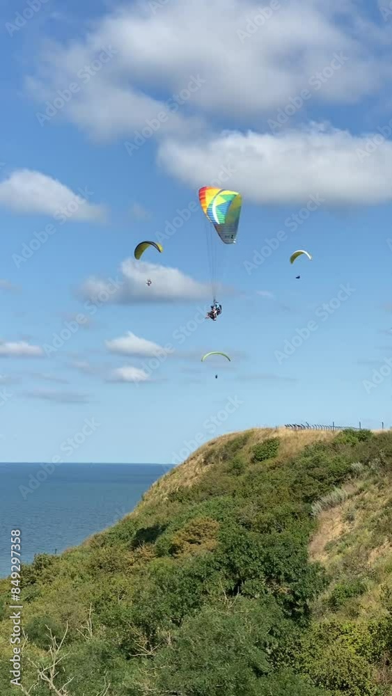 The paraglider flies over the sea. The view of a man on a paraglider flying over the horizon in a clear sky in summer. The concept of outdoor activities in summer. The paraglider flies over the sea. The view of a man on a paraglider flying over the horizon in a clear sky in summer. The concept of outdoor activities in summer.