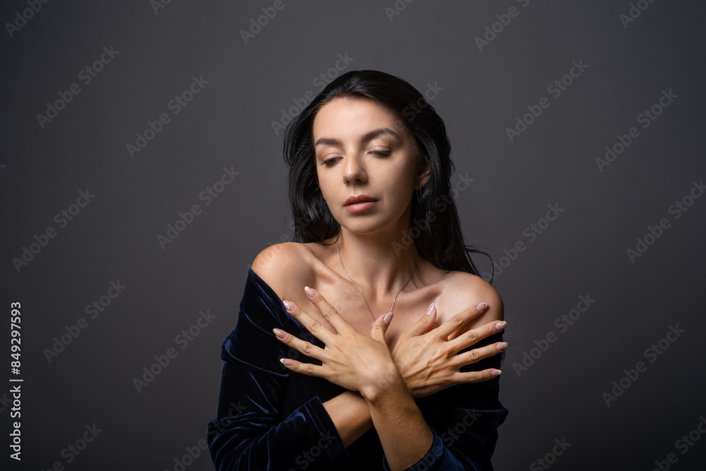 glassy young woman in an evening dress is smiling and posing shyly