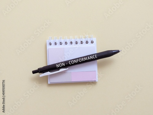 Pen, note pad with the word non-conformance.