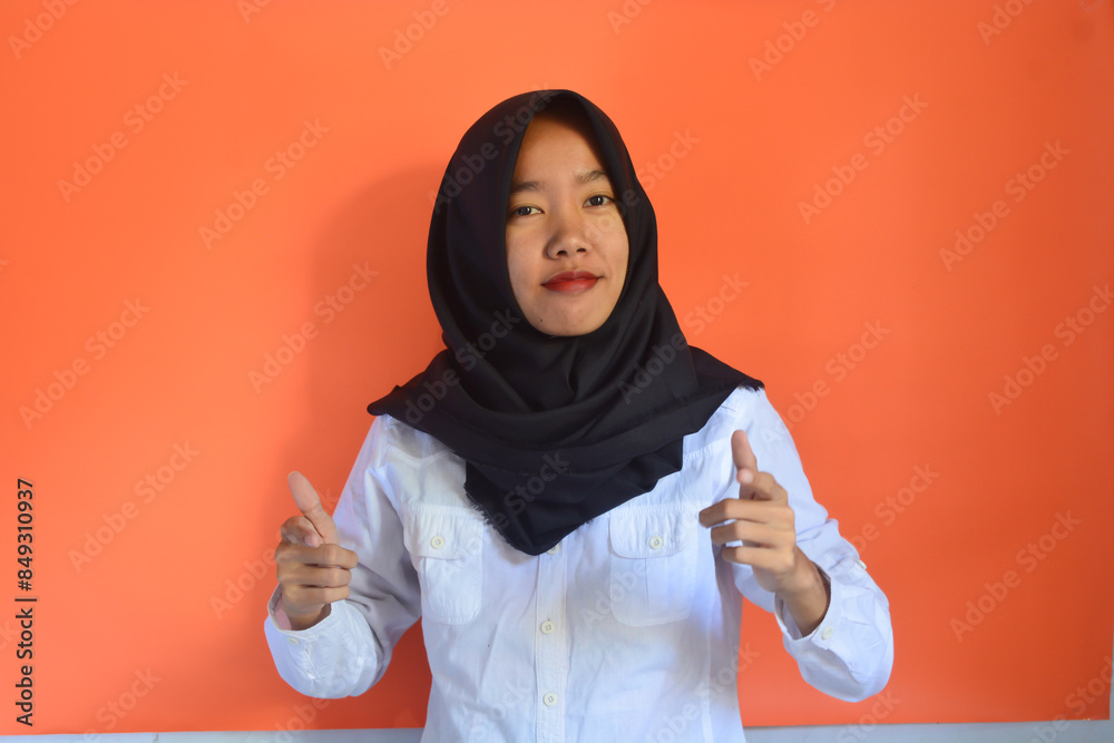 Portrait of an Asian woman wearing a hijab standing confidently and smiling at the camera Portrait of an Asian woman wearing a hijab standing confidently and smiling at the camera