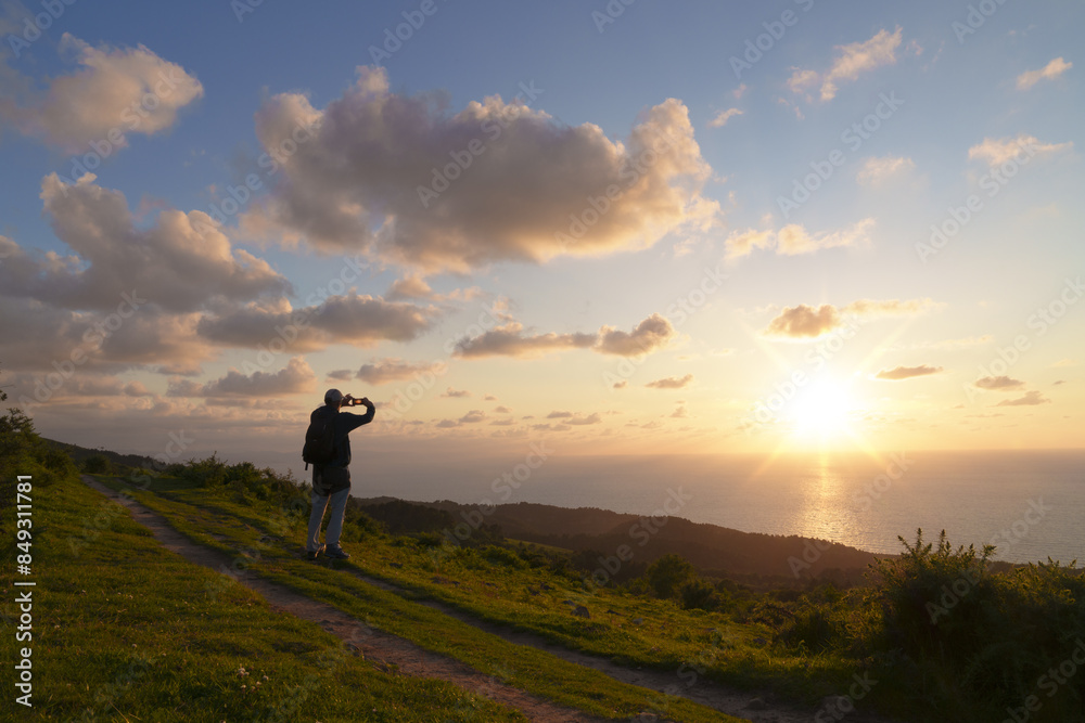 Northern route. Hiker at sunset on the road to Santiago - Camino del norte, mount Jaizkibel, Euskadi Northern route. Hiker at sunset on the road to Santiago - Camino del norte, mount Jaizkibel, Euskadi