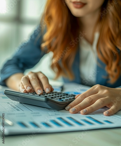 Female accountant using a calculator to make a financial report. 
