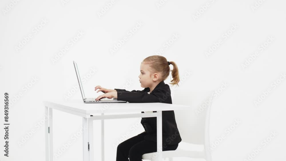 A cute little girl in front of a laptop experiences emotions from an ...