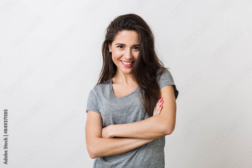 portrait of stylish young pretty woman smiling in grey t-shirt on white studio background, isolated, natural look, long brown hair, crossed arms portrait of stylish young pretty woman smiling in grey t-shirt on white studio background, isolated, natural look, long brown hair, crossed arms