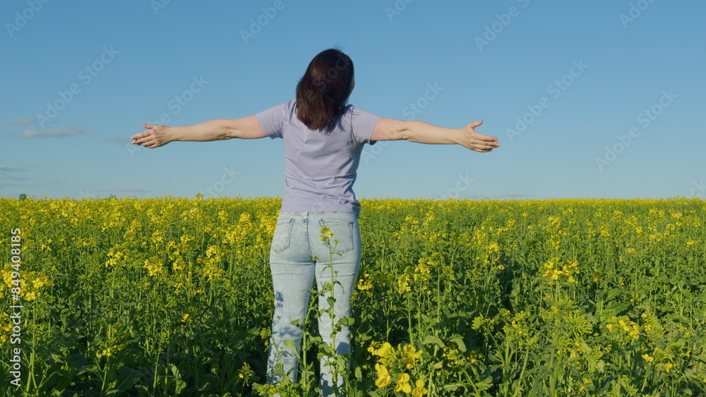 Happy Farmer Woman In A T-Shirt In Blooming Rural Rapeseed Field Enjoying Summer. Freedom Woman Portrait Outdoors At Day In A Yellow Rapeseed Field. Happy Farmer Woman In A T-Shirt In Blooming Rural Rapeseed Field Enjoying Summer. Freedom Woman Portrait Outdoors At Day In A Yellow Rapeseed Field.