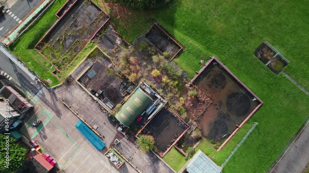 Birds Eye Views of Top down aerial video footage of a chemical plant, factory. Showing chemical storage tanks, cooling towers.
