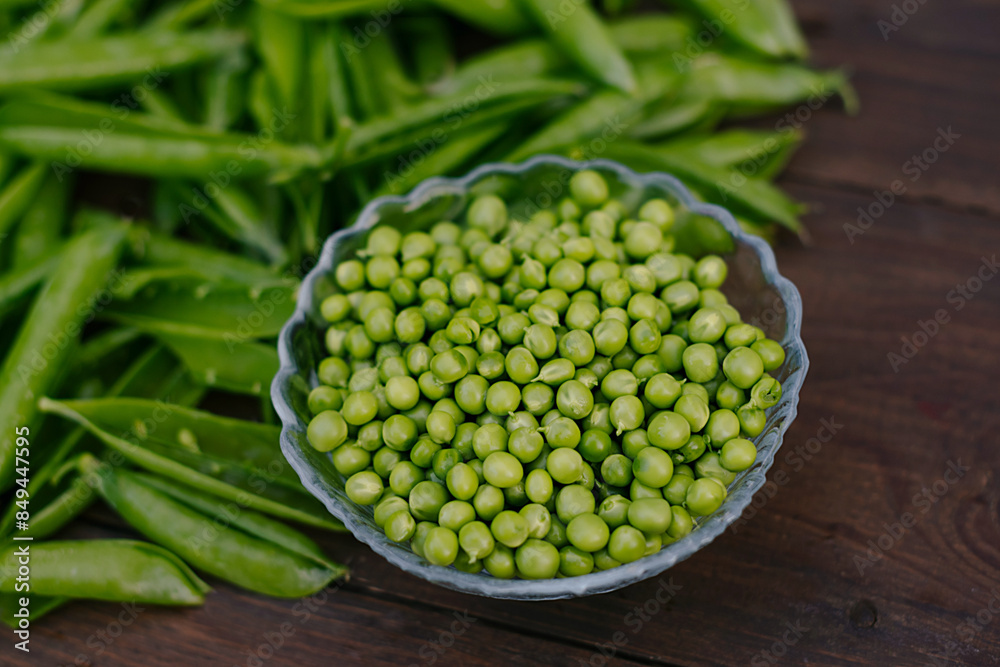 young green peas in pods on wooden background young green peas in pods on wooden background