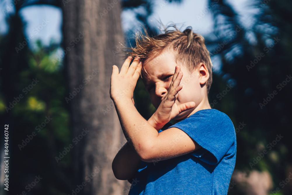 Child boy blue t-shirt karate pose, playing outside summer day. Happy childhood, family education