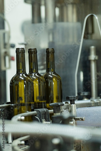 Wine Bottles on Conveyor Belt in Winery Bottling Line photo