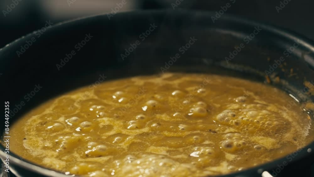 Green boiling sauce texture close-up macro. Cooking green curry with wooden spoon at home. Green boiling sauce texture close-up macro. Cooking green curry with wooden spoon at home.