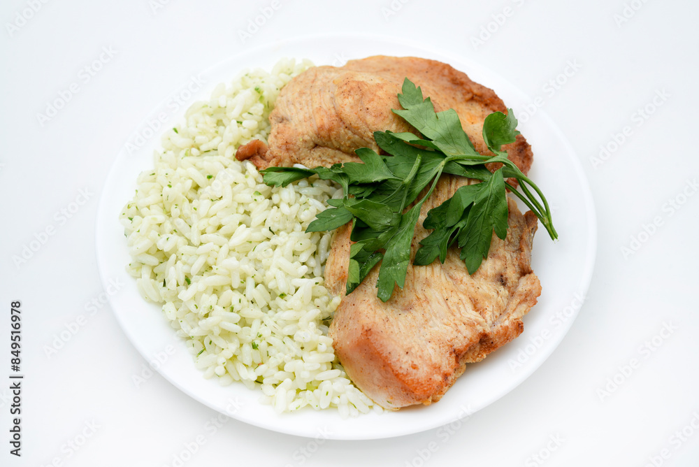 Juicy fried chicken fillet with rice on a plate. Delicious breakfast with meat and rice. Juicy fried chicken fillet with rice on a plate. Delicious breakfast with meat and rice.
