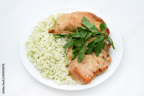 Juicy fried chicken fillet with rice on a plate. Delicious breakfast with meat and rice.