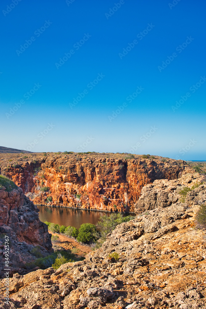 Fototapeta premium Heavily eroded red limestone rocks at the gorge of the Yardie Creek in Cape Range National Park, Western Australia, 