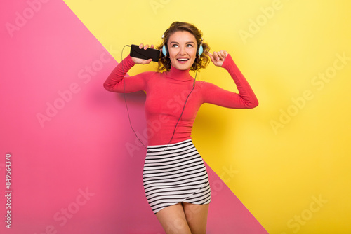 smiling attractive smiling excited woman in stylish colorful outfit dancing and listening to music © mary_markevich