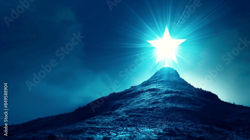 Radiant star shining atop a rugged mountain under a dark blue sky with luminous rays. photo