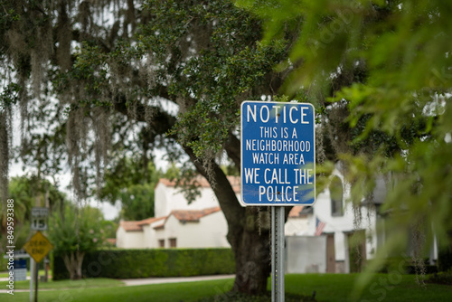 Close-up NOTICE THIS IS A NEIGHBOURHOOD WATCH AREA WE CALL THE POLICE on a  wood lined street, room for copy