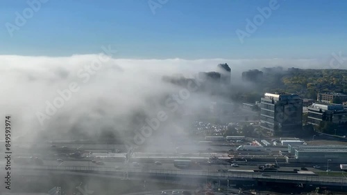 Foggy morning: cloud rapidly moving in over a city in blue sky