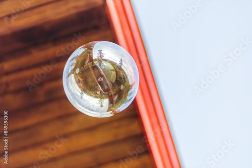 A frog perspective of a soap bubble with wooden roof in the background