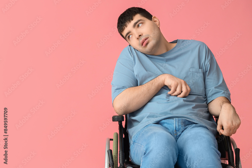 Young man sitting in wheelchair on pink background. National Cerebral Palsy Awareness Month Young man sitting in wheelchair on pink background. National Cerebral Palsy Awareness Month
