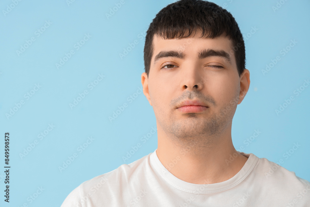 Fototapeta premium Young man on blue background, closeup. National Cerebral Palsy Awareness Month