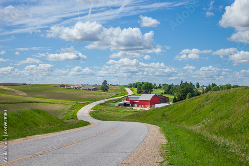 Farm with a red barn on a curving road in the Iowa countryside on a beautiful spring day