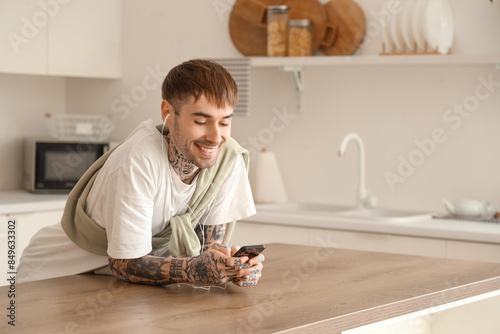 Smiling young man with tatt...