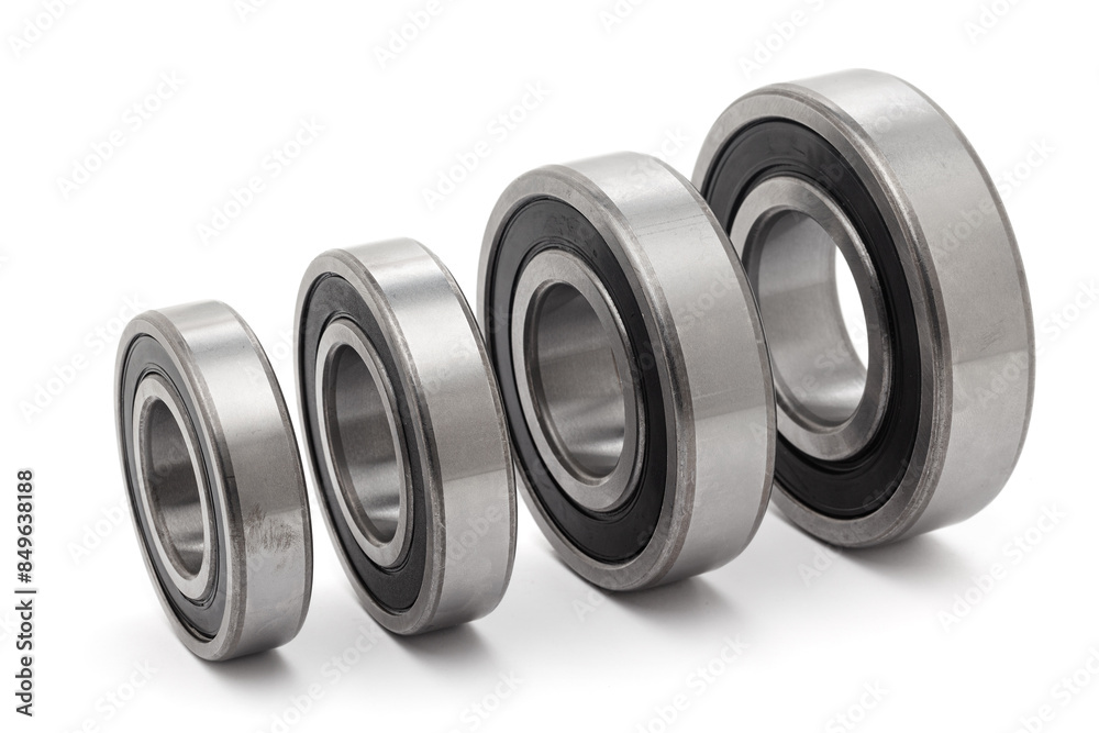 A collection of assorted tapered roller bearings of various sizes, isolated on a white background. A collection of assorted tapered roller bearings of various sizes, isolated on a white background.